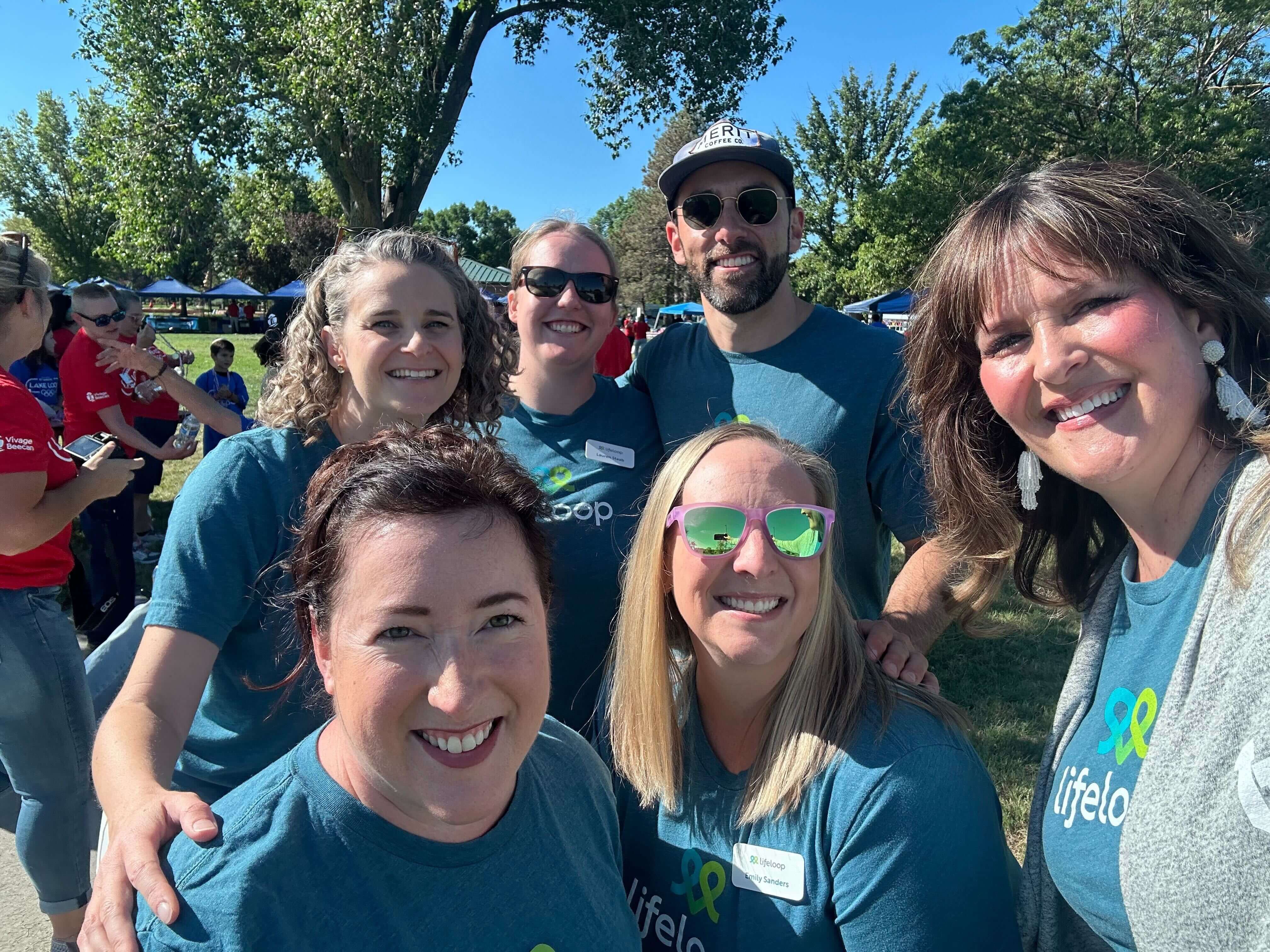 5 women and 1 man smiling in blue shirts