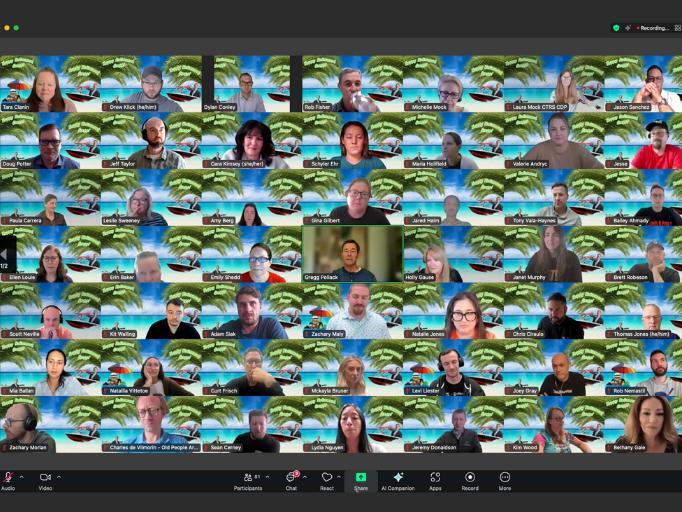 Large group smiling on Zoom call celebrating a teammate’s retirement.